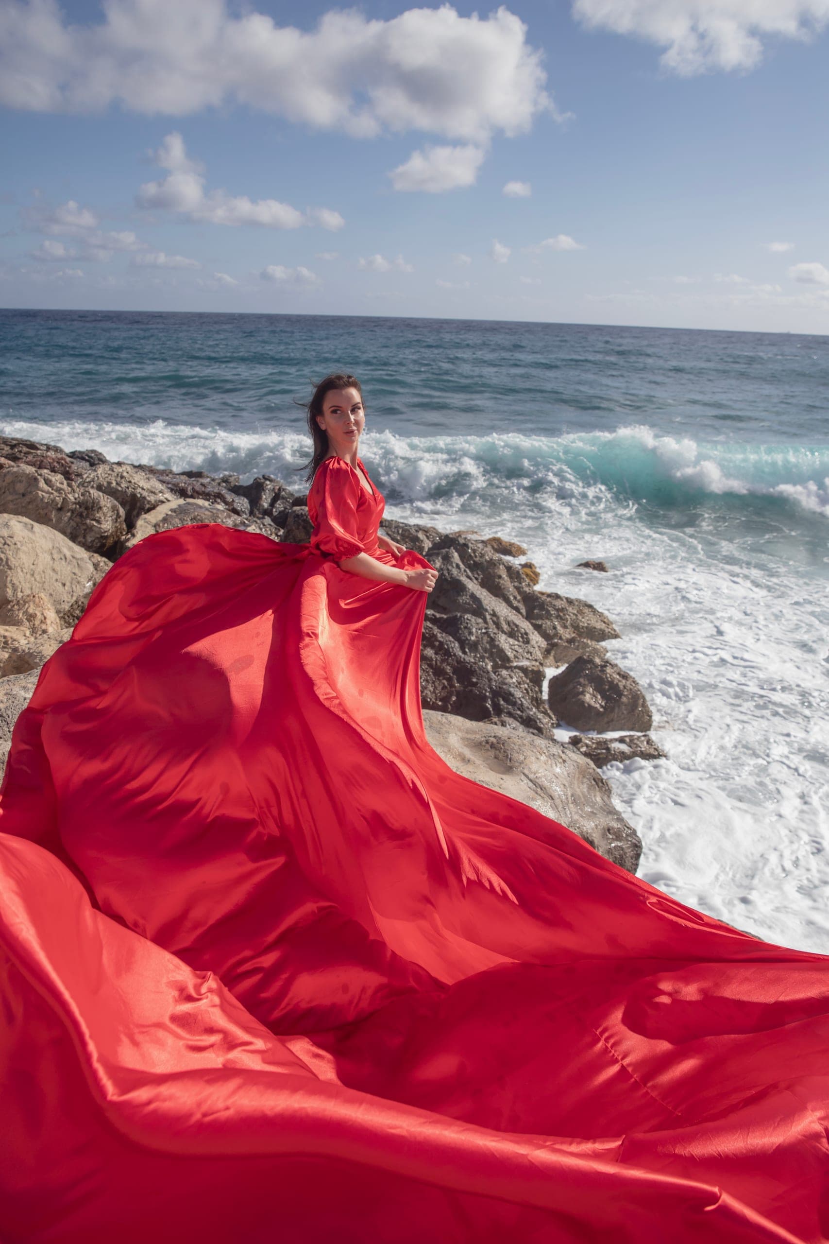 Flying dress photography in a red dress on the Cyprus coast